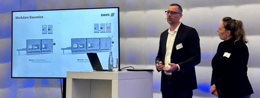 Felix Strangmann und Sandra Szech erklären auf der NORTEC eine modulare BAADER-Maschine und diskutieren über Produktbaukästen im Maschinenbau